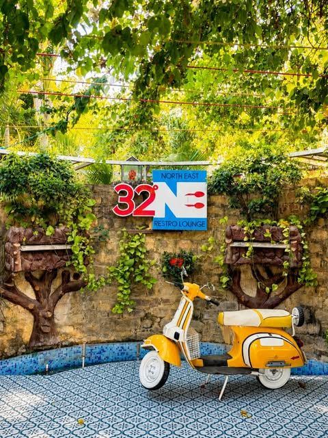 Yellow scooter in front of the 32 NE logo wall